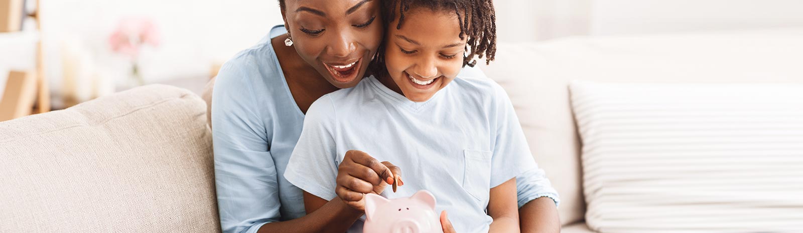 Woman and child putting money into a piggy bank.